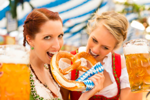 Young women in traditional Bavarian clothes - dirndl or tracht - on a festival or Oktoberfest in a beer tent